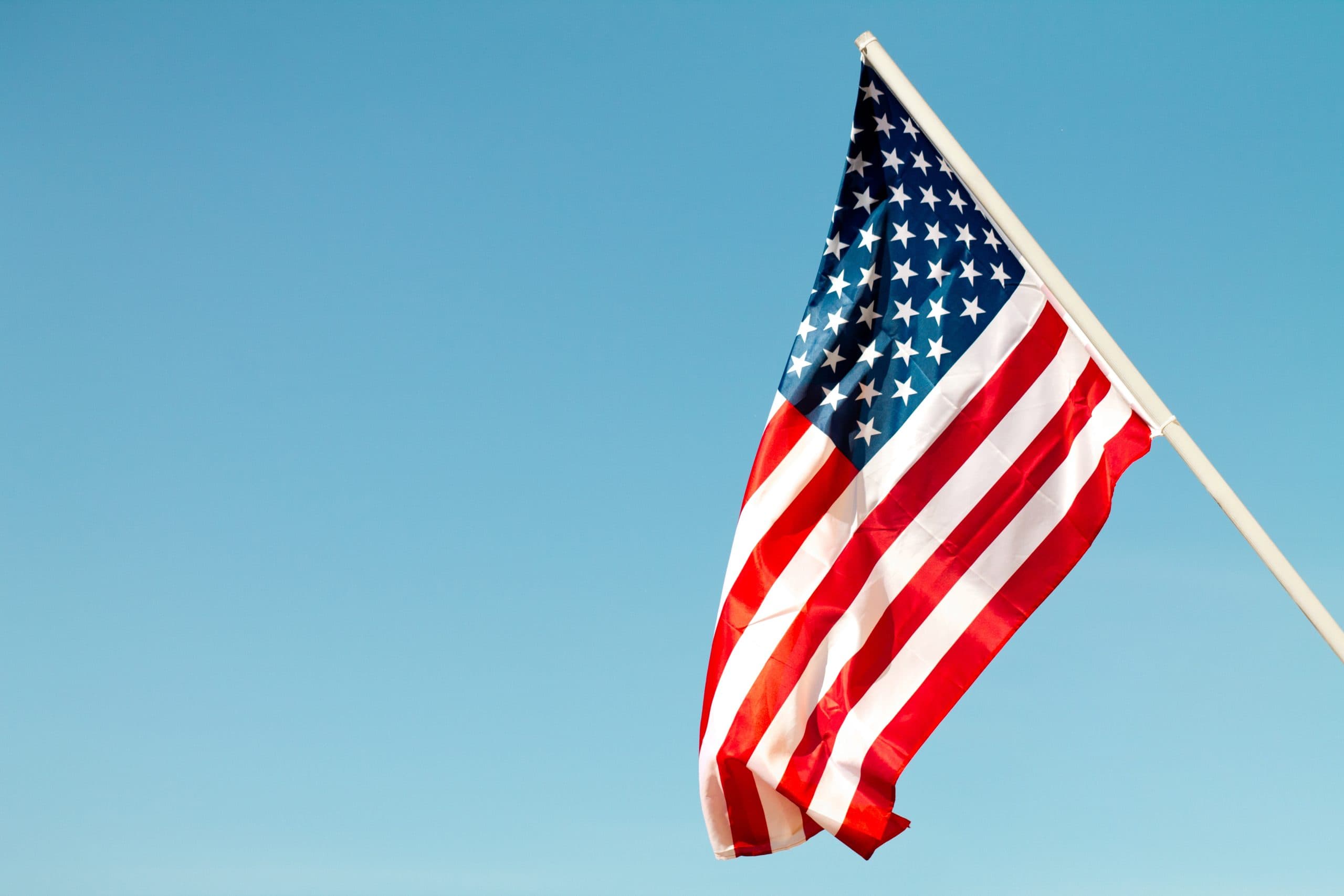 The American flag waving against a clear blue sky